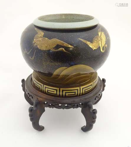 A Japanese jardiniere / planter with a bulbous lacquered body decorated with flying cranes