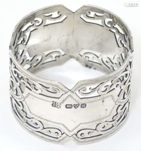 A silver napkin ring with pierced decoration hallmarked Chester 1912 Barker Brothers.
