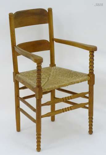 An Arts & Crafts open armchair with ladder back style backrest,