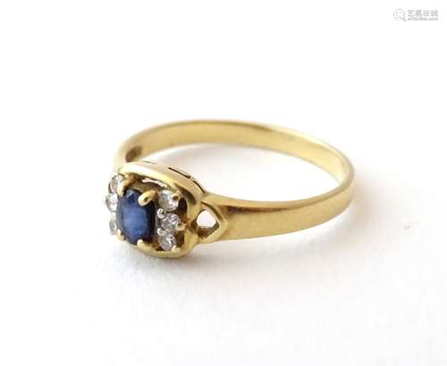 An 18ct gold ring set with sapphire flanked by diamonds.