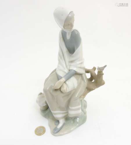A Lladro 'New Shepherdess' figurine of a girl sat watching a bird, makers mark to base,