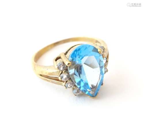 A 9ct gold ring set with pear cut topaz flanked by white stones. Ring size approx.