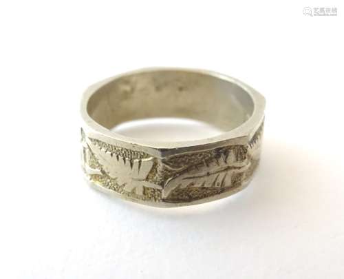 A white metal ring with foliate decoration.