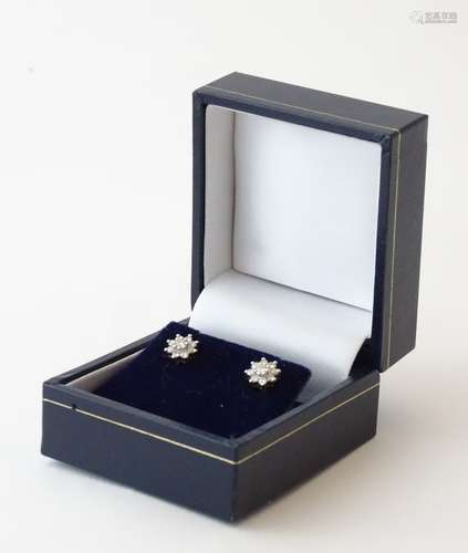 A pair of 9ct gold earrings set with diamond clusters.