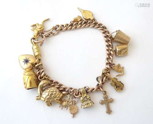 A 9ct gold and gilt metal charm bracelet set with various charms.