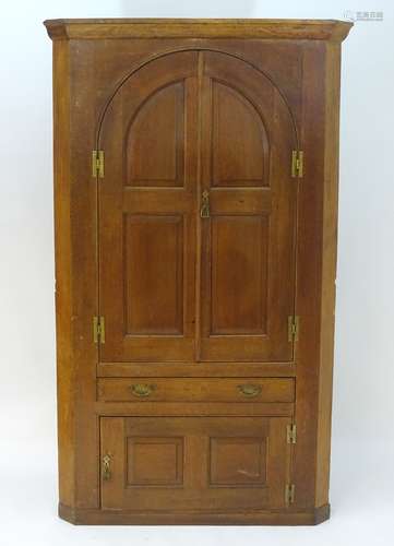 A late 18thC / early 19thC oak corner cupboard with a bowed back,