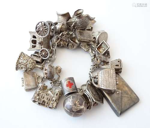 A silver and white metal charm bracelet with various charms including a silver carriage,