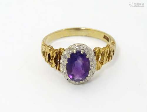 An 18ct gold ring set with central amethyst bordered by diamonds.