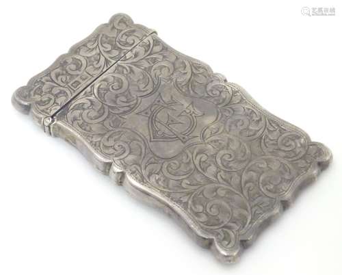 A silver visiting card case with engraved acanthus scroll decoration.