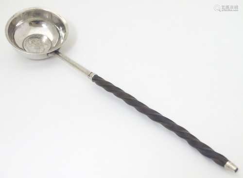 A 19thC toddy ladle with white metal bow hanging inset Geo III coin to centre.