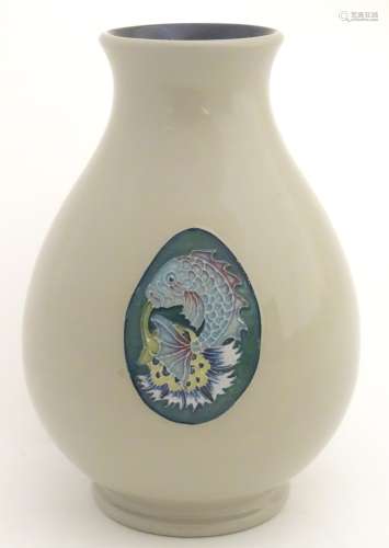 A Moorcroft trial vase in the shape 7/5, decorated with a fish and thistle design.