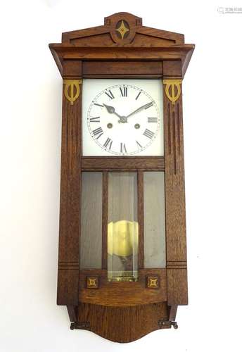 An Edwardian regulator wall clock, oak cased with decorative brass plates,