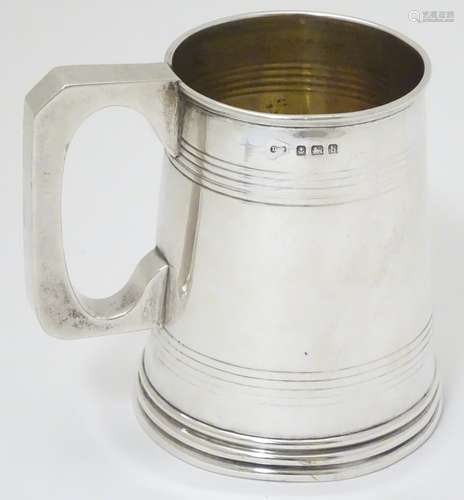 A silver mug / Christening cup of tankard form with banded decoration.