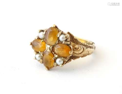 A 9ct gold ring set with citrines and seed pearls with acanthus scroll decoration to shoulders.