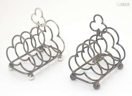 A pair of silver plate toast racks with 5 divisions of trefoil form and central handle.