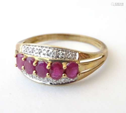 A 9ct gold ring set with 5 rubies in a linear setting flanked by chip set diamonds.