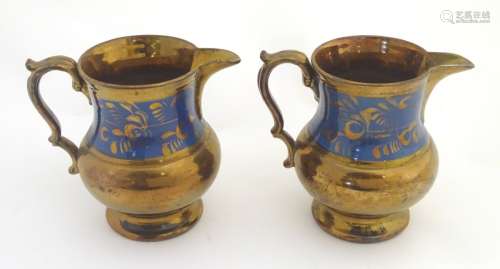 A pair of Victorian copper lustre ware jugs with banded cobalt foliate decoration. Approx.