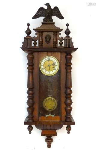 An early 20thC regulator wall clock, the carved mahogany and pine case with glazed door,