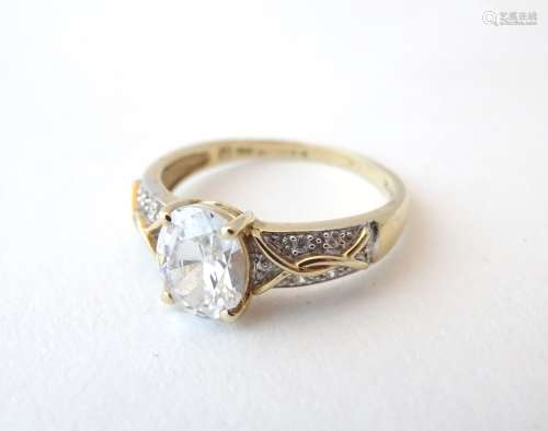 A 14ct gold ring set with central cubic zirconia flanked by further cubic zirconias.