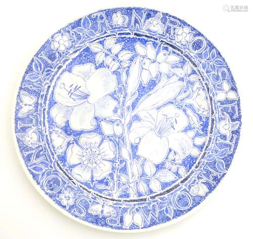 A 20thC blue and white hand painted plate decorated with flowers, lilies, foliage and butterflies.