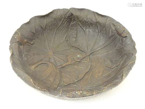 A Japanese Meiji carved wooden bowl decorated in relief with lily pads, lotus flowers and frogs.