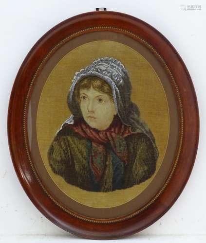 A Victorian wool and bead work depicting a portrait of a woman, within an oval frame. Approx.