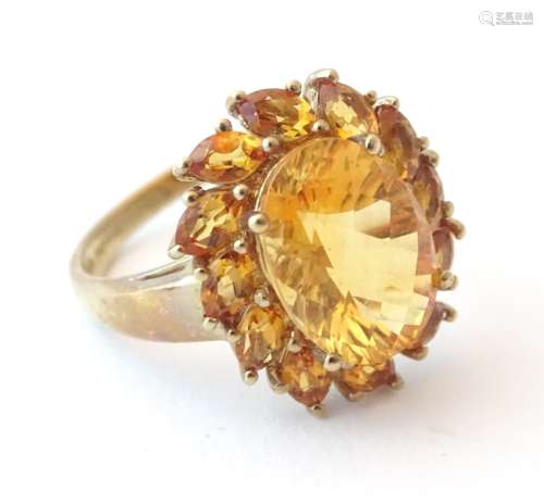 A 9ct gold dress ring set with central facet cut citrine bordered by further citrines.
