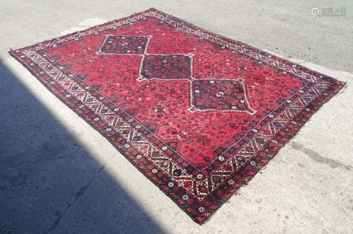 Carpet / Rug : A red ground rug with banded and foliate decoration and central geometric detail.