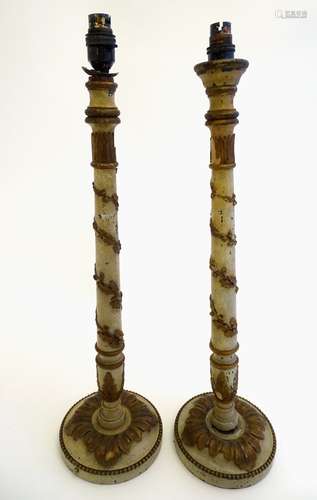 A pair of carved wooden table lamps, each decorated with moulded,