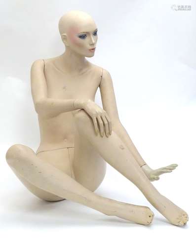 A 20thC female seated shop display mannequin with articulated, posable limbs. Seated height approx.