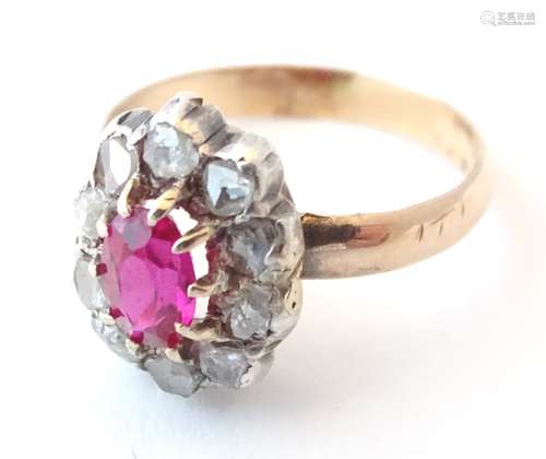 A gold ring set with central ruby bordered by diamonds (unmarked, tests as 14ct). Ring size approx.