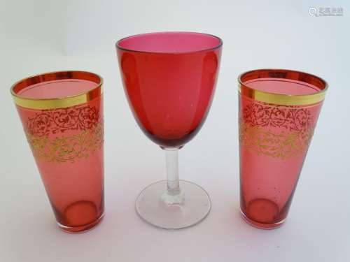 Two cranberry glasses beakers / pony measures with gilt decoration together with a cranberry glass