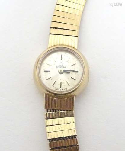 A ladies Omega 9ct gold cased wristwatch with 9ct gold strap.