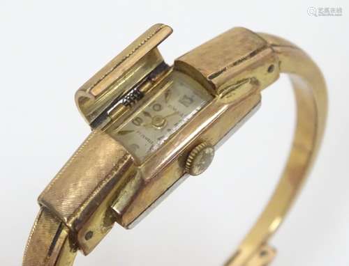 A 20thC gold plated bangle formed wristwatch with sprung hinged central section,