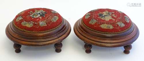 A pair of Victorian mahogany footstools with overstuffed beadwork tops and moulded frames raised on