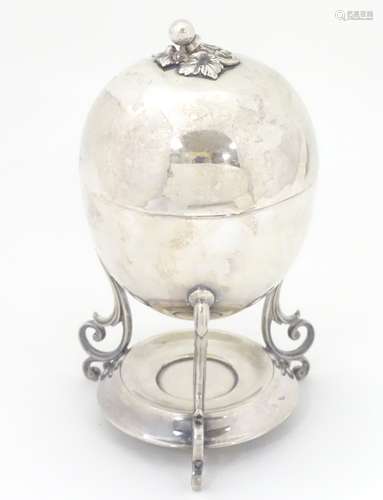 A William Hutton & Sons Cross Arrows silver plate egg coddler of oval form raised on three scrolled