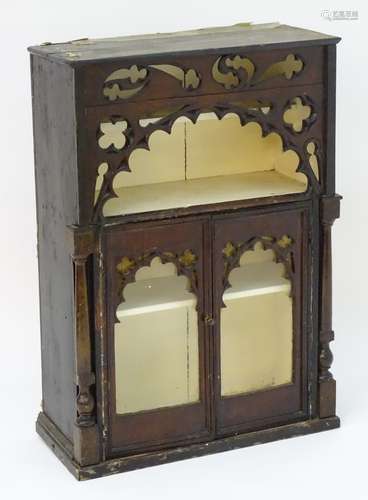 A Gothic cabinet with a rectangular top above pierced decoration to the frieze and an open shelf