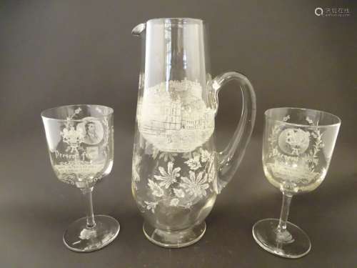 A souvenir glass jug and two wine glasses decorated with etched detail titled ' A Present from