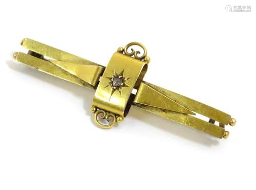 A gold bar brooch set with central diamond,