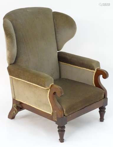 A Victorian wingback adjustable armchair with scrolled arms,