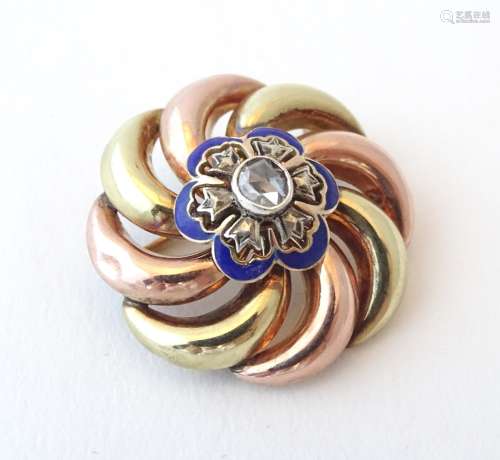 A yellow and rose gold brooch with blue enamel detail and central diamond. The diamond approx. 0.
