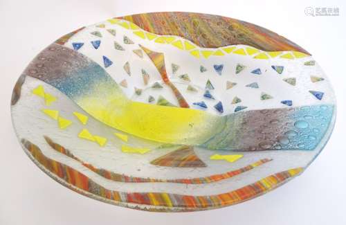 A large studio art glass charger decorated with fused coloured glass detail.