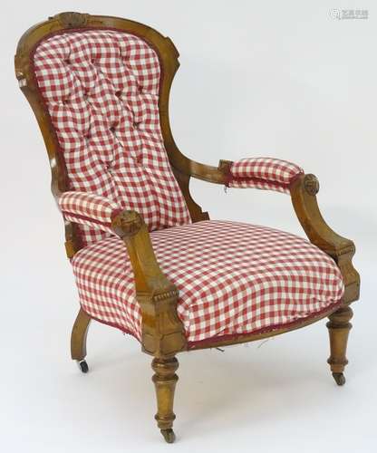 A late 19thC open armchair with a shell carved frame above a deep buttoned back rest and sprung