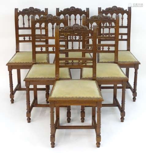 A set of six 20thC oak dining chairs with carved cresting rails and turned supports to the