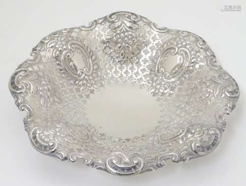 A silver dish with embossed and pierced decoration.