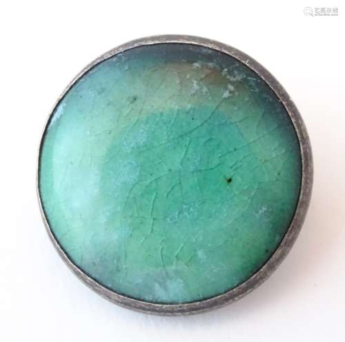 An Arts & Crafts white metal brooch set with ceramic green Astra Minton high fired cabochon. Approx.