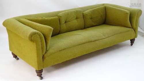 A large Victorian Chesterfield style sofa raised on turned legs terminating in ceramic castors.