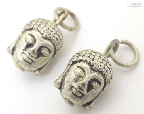 A pair of novelty white metal charms formed as buddha heads. ( Unmarked, tests as silver).