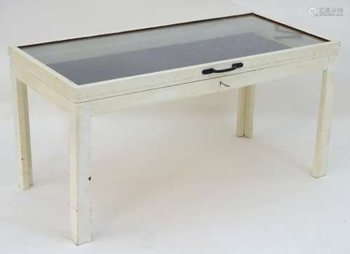 A 20thC glass display table / vitrine with a rectangular glazed top above four supports.