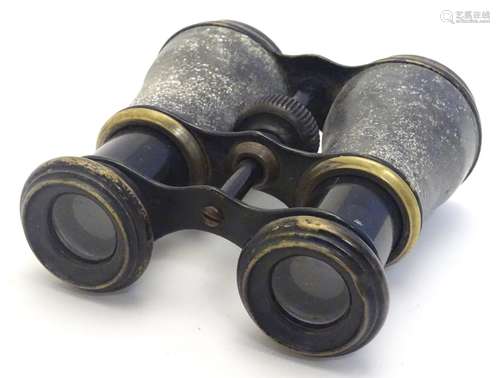 A pair of early 20thC binoculars, of brass construction with blacked finish.